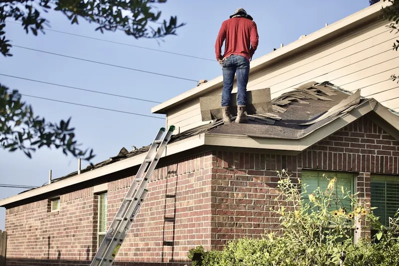 Professional roofer working on a residential roof in Sardis Estates